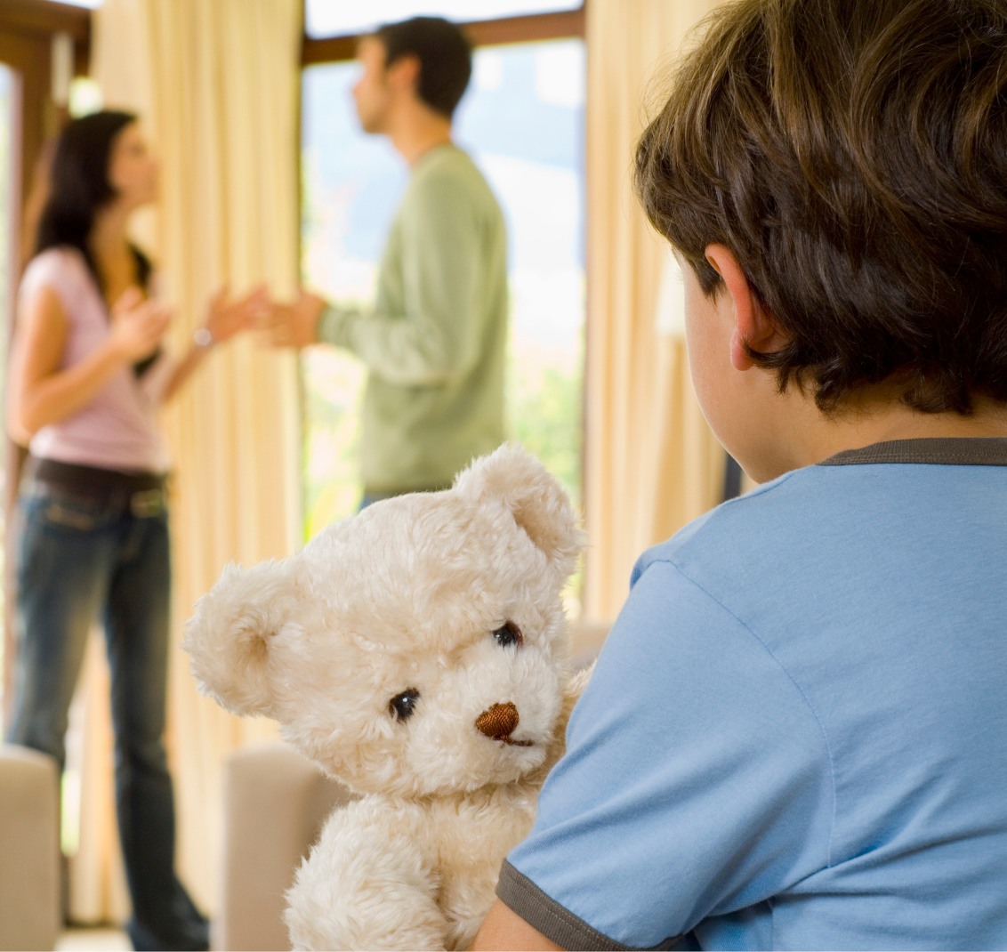 a boy in a blue shirt holding a bear watching his parents fight over family law and child custody during their divorce