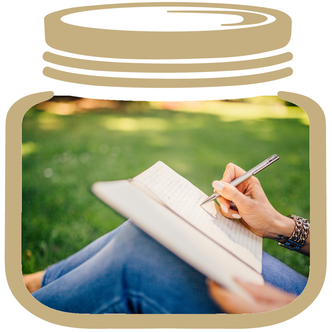A gold my lifejar, inside a picture of a women sitting on the grass writing how to journal your life.