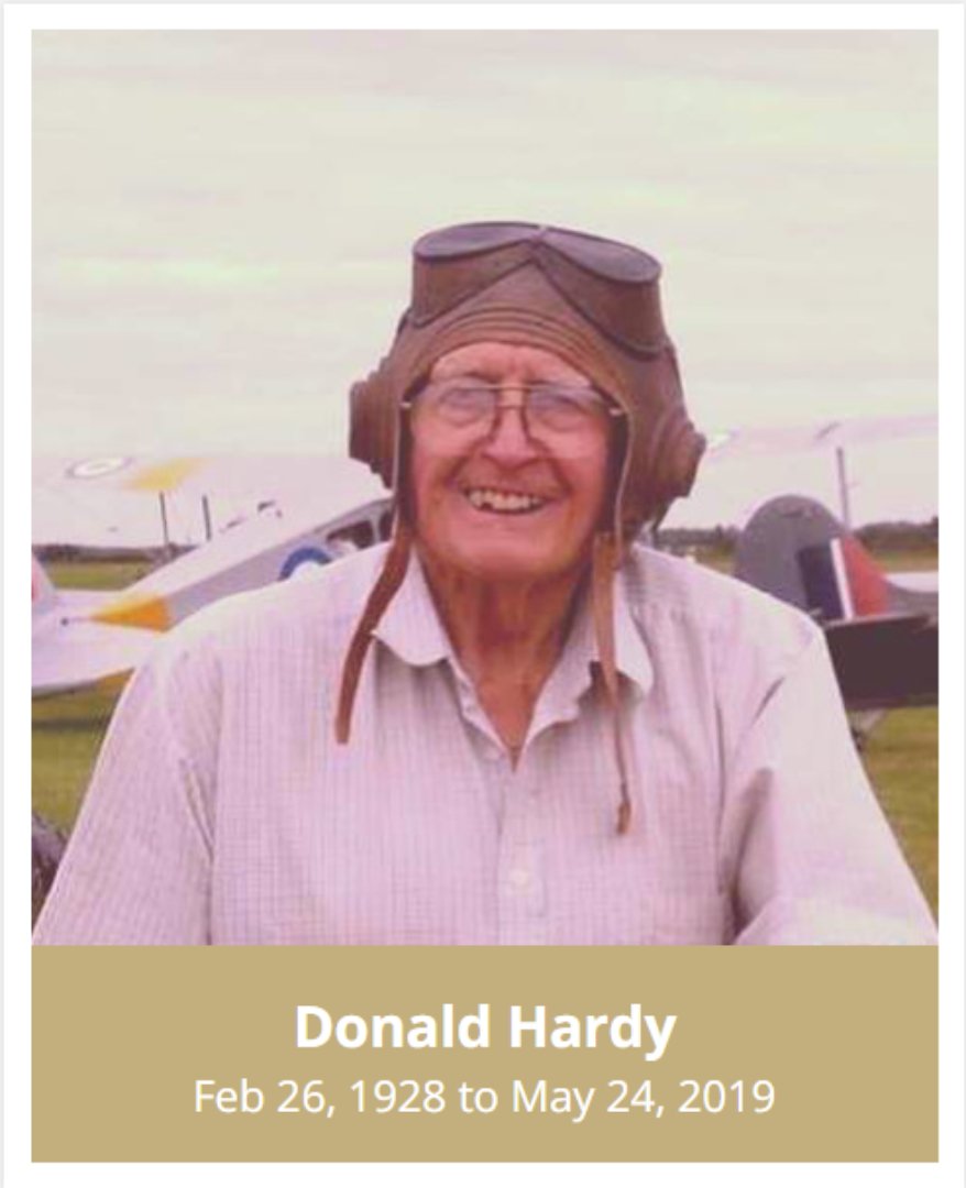 a smiling elderly man with aviator mask, gold bar at bottom with his name, birth date and date of death for an online line tributes